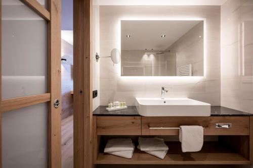 a bathroom with a sink and a mirror at Small & Beautiful Hotel Gnaid in Tirolo