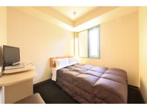 a hotel room with a bed and a desk with a computer at R&B Hotel Sendai Hirosedori Ekimae - Vacation STAY 39668v in Sendai