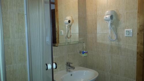 uma casa de banho com um lavatório e um telefone na parede em Hanna Szobái em Tarcal