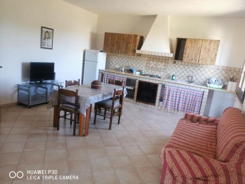 a kitchen with a table and chairs and a couch at Case vacanze Baglio Sances in Birgi Vecchi