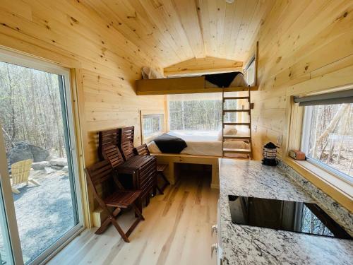 a tiny house with a desk and a bed at Trailside Stays in Rumney