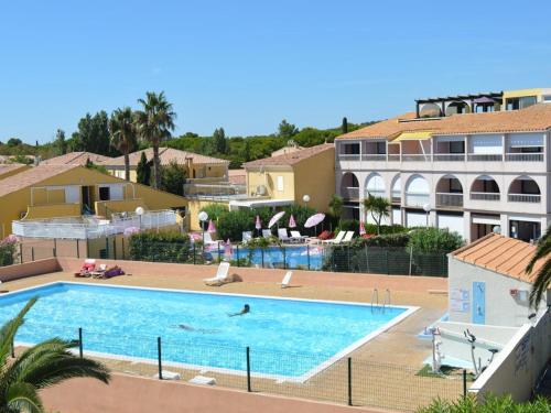 - une personne se baignant dans une piscine d'un complexe dans l'établissement Studio 2 pers avec terrasse et piscine au Cap d'Agde - FR-1-249A-25, au Cap d'Agde