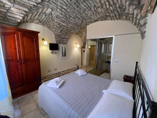 a bedroom with a bed and a mirror at La Vecchia Torre in Bosa