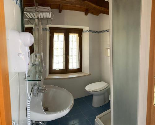 La salle de bains est pourvue d'un lavabo et de toilettes. dans l'établissement Chiaraluce Country House, à Massignano