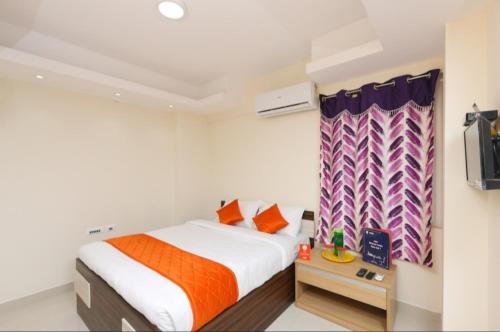 een kleine slaapkamer met een bed en een televisie bij PHOENIX INN in Chennai