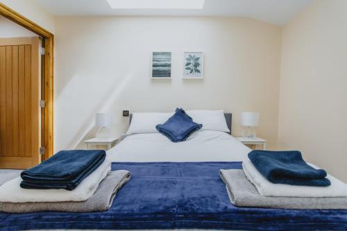 a bedroom with a bed with blue towels on it at Spacious 2nd Floor Apartment - King Size Bed & Free Parking in Nottingham