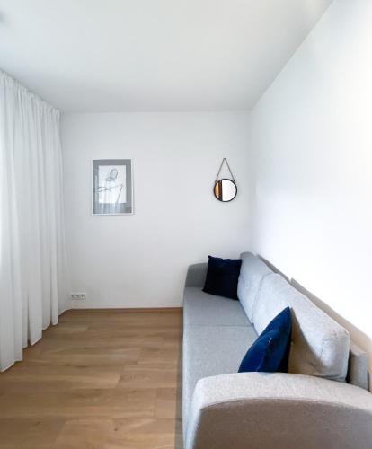 ein Wohnzimmer mit einem grauen Sofa und blauen Kissen in der Unterkunft Lovely 2-bed apartment with everything you need. in Reykjavík