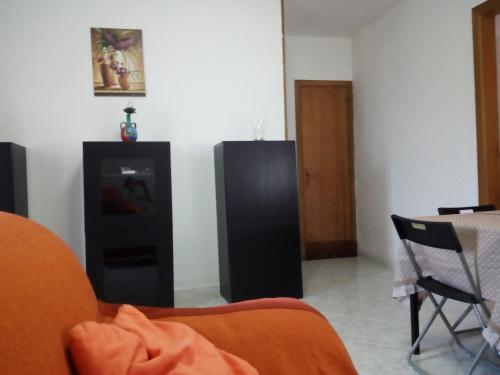 een woonkamer met een bank en een zwarte koelkast bij Casa da nonna Carmela in Montecorice