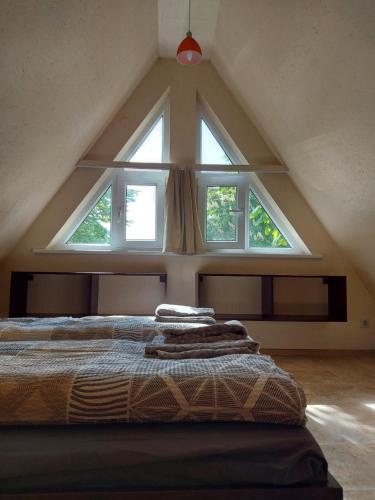 a bed in a room with a large window at Namelis ir marios in Nida