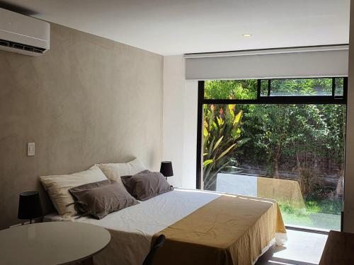 een slaapkamer met een bed en een groot raam bij The owl lodge in Ciudad Lujan de Cuyo