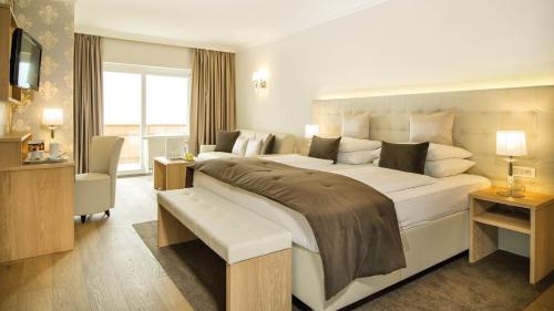 a large bedroom with a large bed and a window at Small & Beautiful Hotel Gnaid in Tirolo