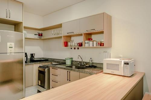 a kitchen with a white microwave on a counter at Aconchegante apartamento em Campos do Jordão, região Capivari - PET friendly# in Campos do Jordão