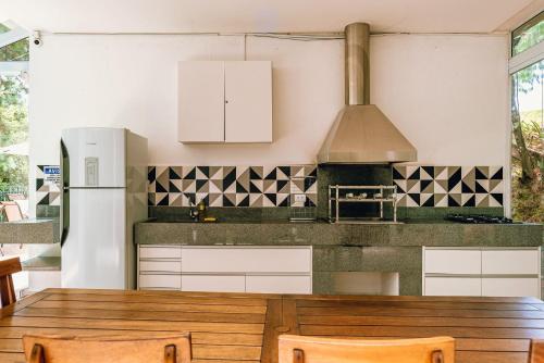 a kitchen with white cabinets and a wooden table at Aconchegante apartamento em Campos do Jordão, região Capivari - PET friendly# in Campos do Jordão