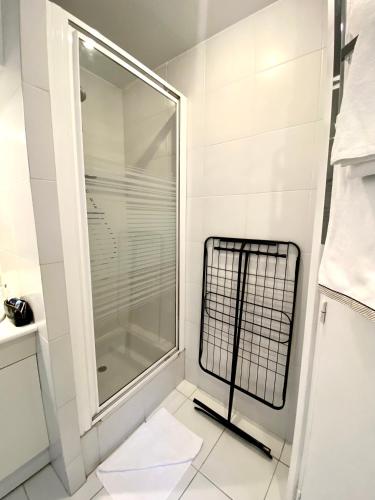 une douche avec une porte vitrée dans une salle de bain dans l'établissement ÉLÉGANT STUDIO et PARKING DANS BATIMENT HISTORIQUE, à Saint-Tropez