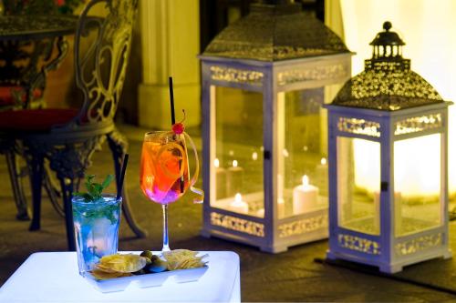 a table with two lanterns and a drink and a glass at Hotel Villa San Lorenzo Maria in Rome