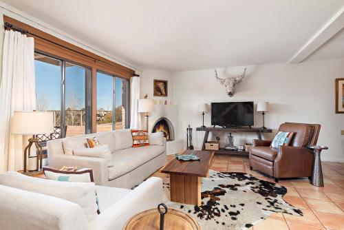 a living room with a couch and a tv at Fort Marcy Suites by All Seasons Resort Lodging in Santa Fe