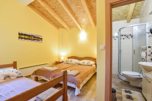 a bedroom with a bed and a shower and a toilet at Holiday home with swimming pool, donkeys and horses in Vrlika