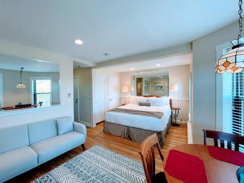 a bedroom with a bed and a couch and a table at Copley House Extended Stay in Boston