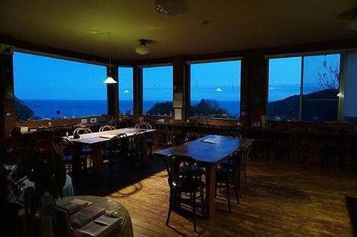 a restaurant with tables and chairs and a view of the ocean at Tennyoza Entertainment Guest House - Vacation STAY 13010 in Kumano