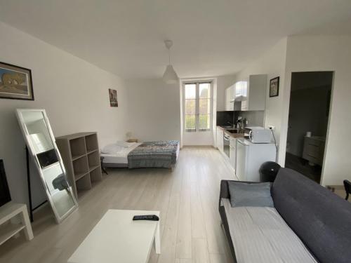 ein großes Wohnzimmer mit Couch und Tisch in der Unterkunft Appartement Rénové avec Cuisine Américaine et WIFI, Proche des Thermes Saint Roch - FR-1-541-32 in La Roche-Posay