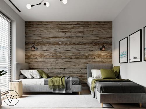 a bedroom with two beds and a wooden wall at Apartament z widokiem na Zatokę Gdańską in Gdańsk