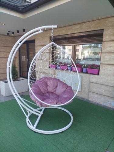 a white swing with a purple chair in a room at Sunset Lux S3 Wellness & Spa Zlatibor in Zlatibor