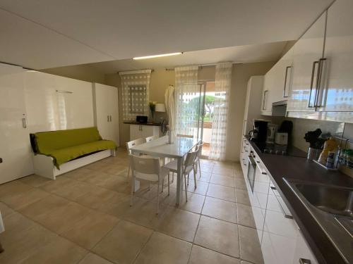 une cuisine et un salon avec une table et un canapé dans l'établissement Appartement proche plage, climatisé, 5 pers – Sainte-Maxime - FR-1-226-427, à Sainte-Maxime