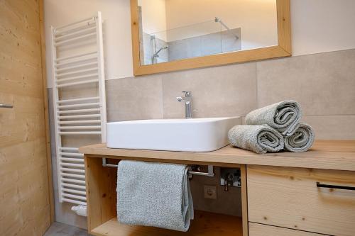 La salle de bains est pourvue d'un lavabo, d'un miroir et de serviettes. dans l'établissement Der Luemerhof, à Marlengo