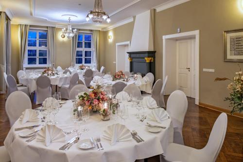 a banquet room with white tables and white chairs at Schloss Rattey in Schönbeck