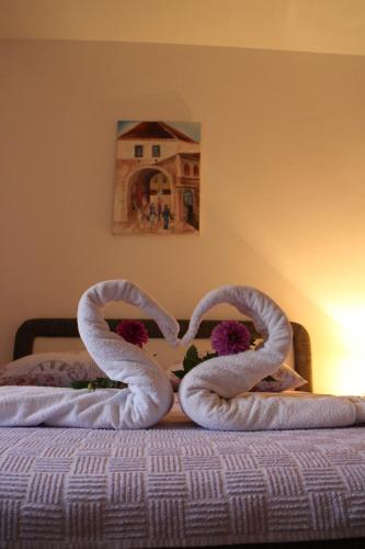 due cigni che fanno un cuore su un letto di Apartman Anja a Trebinje