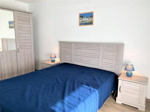 - une chambre avec un lit bleu et 2 tables de chevet dans l'établissement Charmant T2 à Quiberon, balcon sud, parking, à 300m des commerces et plage - FR-1-478-162, à Quiberon