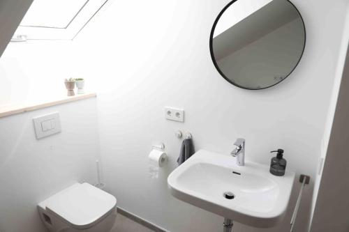 a white bathroom with a sink and a mirror at Pegnitz Apartement in Pegnitz