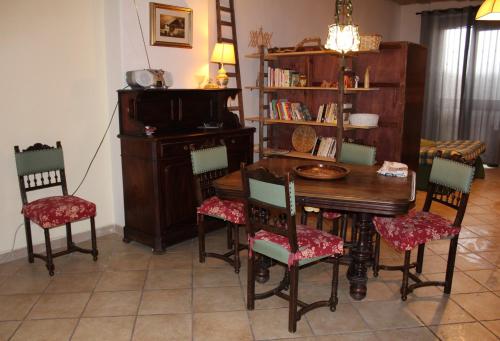 ein Esszimmer mit einem Tisch, Stühlen und einem Klavier in der Unterkunft L'Angoletto in Trecastagni