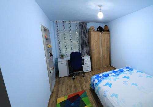 una camera con letto, scrivania e sedia di apartament Ramnicu Valcea a Râmnicu Vâlcea