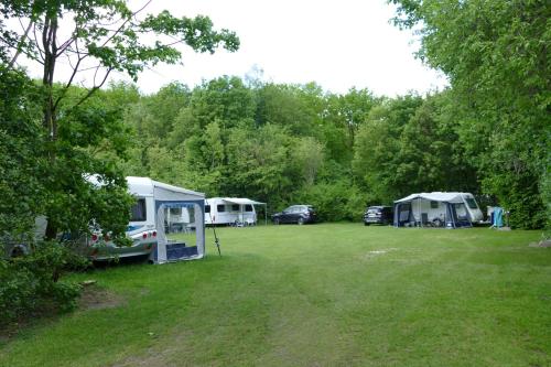 un groupe de tentes et de voitures garées dans un champ dans l'établissement Lege Kampeerplaats + Prive Sanitair, Camping Alkenhaer, à Appelscha