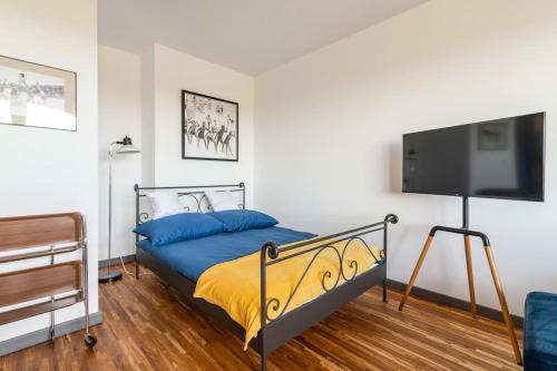 a bedroom with a bed and a flat screen tv at Apartament przy Aquaparku in Reda