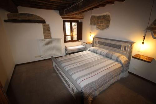 casa vacanze Castiglione - 4 posti letto في Castiglione della Valle: غرفة نوم بسرير كبير ونافذة