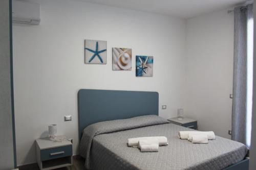 a bedroom with a bed with two towels on it at Akoya Apartments in San Vito lo Capo