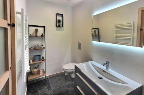 a bathroom with a sink and a toilet and a mirror at Superbe, T3 spacieux 78 m2, Neuf, Parking, Balcon in Gerde