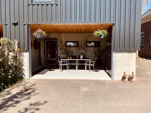 un patio avec une table et des chaises dans un bâtiment dans l'établissement Vakantiewoning Kalverliefde, à Zeerijp