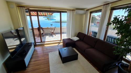 a living room with a couch and a flat screen tv at Magic Sea View in Tsarevo