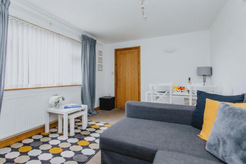 a living room with a blue couch and a table at 2 Bedroom Garden Apartment Near QMC, Tennis Centre & City in Nottingham