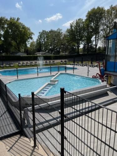 a large swimming pool with a fountain in a park at Chalet vakantie Wageningen in Wageningen