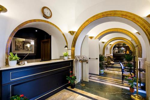 a lobby with arches and a clock on the wall at Hotel Villa San Lorenzo Maria in Rome