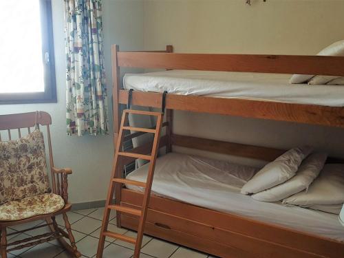 - une chambre avec 2 lits superposés et une chaise dans l'établissement Appartement T3 avec parking à Argelès-sur-Mer, 2 chambres, cuisine équipée pour 4/6 pers. - FR-1-388-187, à Argelès-sur-Mer