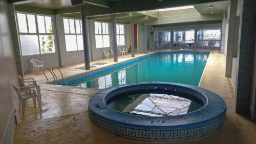 una gran piscina con una gran bañera azul en San Remo World Hotel en San Clemente del Tuyú