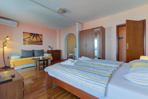 a hotel room with two beds and a couch at Apartment Žuna in Senj