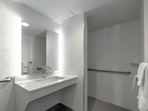 a white bathroom with a sink and a shower at Baymont by Wyndham White Plains - Elmsford in Elmsford