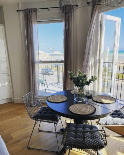 a dining room with a table and chairs and a balcony at Seaview flat with balcony, spacious 2 bedroom in Worthing