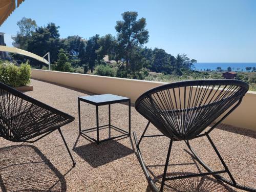 two chairs and a table on a balcony at THEASIS 4 luxury studio with sea view in Neos Marmaras